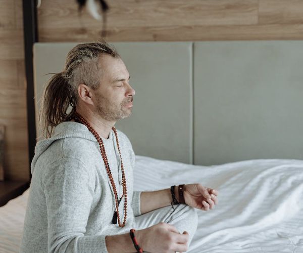 A person meditating peacefully, surrounded by an aura of calm energy.